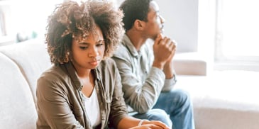emotionally distant couple sitting apart from each other