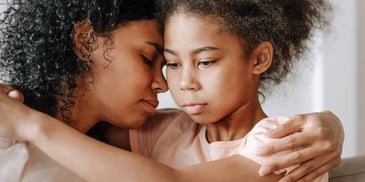 sad mother and daughter hugging