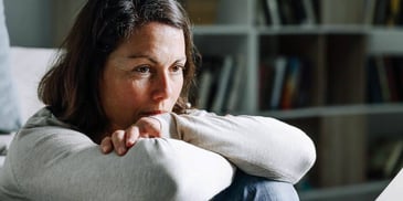 guarded woman sitting alone in the dark