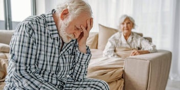 a couple of seniors looking sad after a fight in their bedroom