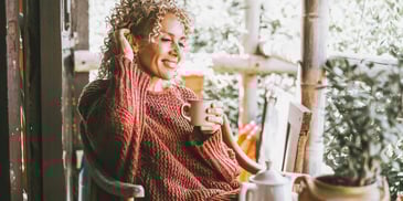 happy single woman at home relaxing with a cup of tea