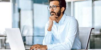 man in deep thought at his work desk