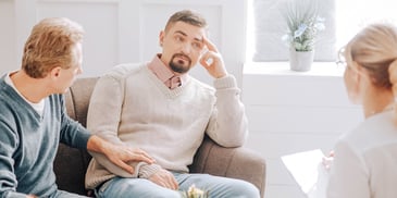 Two men meet with a therapist