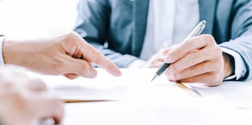 two people at a desk filling out paperwork