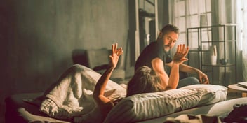 woman in bed recovering from a hangover and arguing with her husband