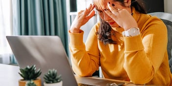 unhappy woman sits at laptop wondering what to do about her divorce petition
