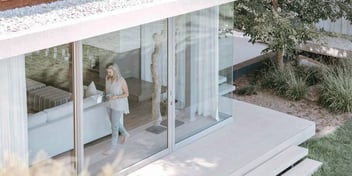 woman who is home alone standing by a window