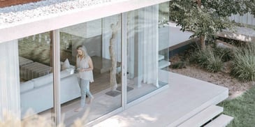 woman who is home alone standing by a window