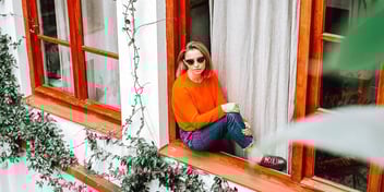visually impaired woman sitting on a windowsill