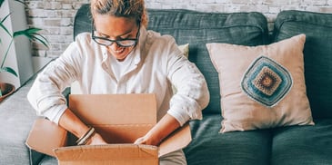 woman packing a box of items for sale