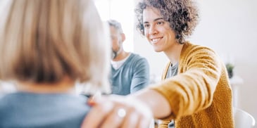 Woman comforts another woman in a divorce support group