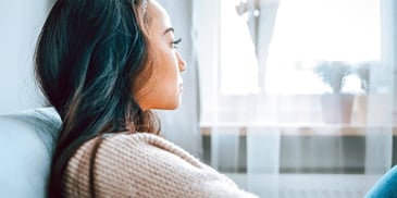woman deep in thought looking out a window
