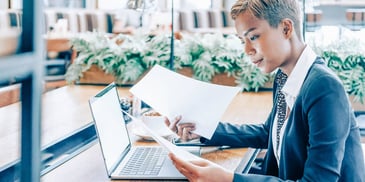woman sitting at a laptop doing financial paperwork and planning