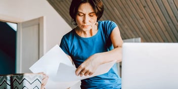 woman sorting through a bunch of paperwork and mail