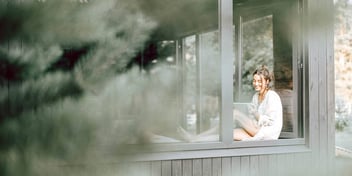 woman sitting in a windowsill of a house