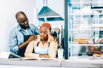 man rubbing woman's shoulders but she is ignoring him
