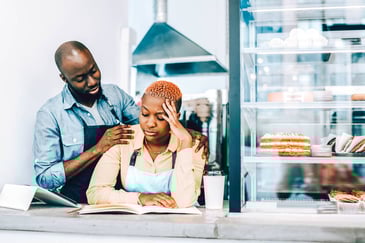 man rubbing woman's shoulders but she is ignoring him