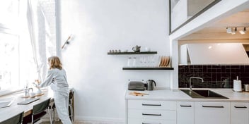 Woman in kitchen looking out of the window