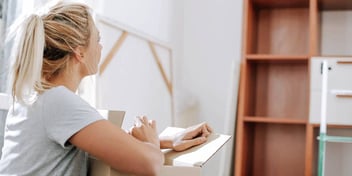 woman standing in her marital home packing up to move