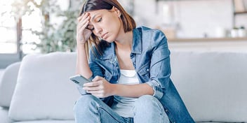 A woman looks at her smartphone as she considers divorcing her spouse