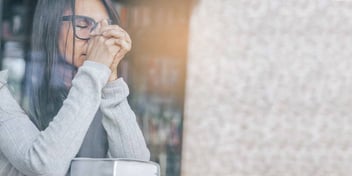 Woman looks out the window seeming upset