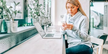 Woman looks at phone while she fills out her divorce paperwork online