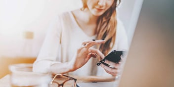 Woman uses her phone to calculate her student loan payments