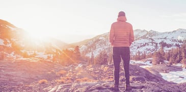 Woman looks out over a snowy mountain
