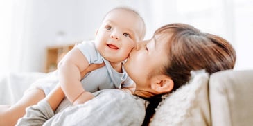 mom kissing her baby