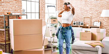 woman rocking out to music as she moves into her new home