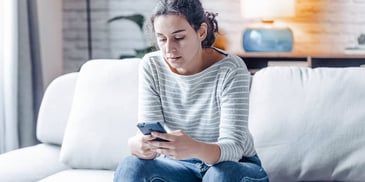 woman looking at her phone search for missing spouse