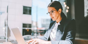 Young woman working on her laptop wearing a suit