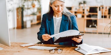 woman looking over financial paperwork