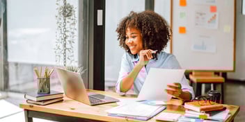 woman completing paperwork at her desk