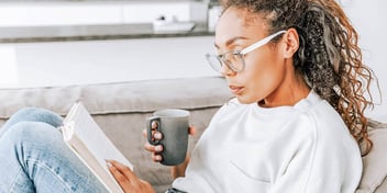 woman reading book and drinking tea