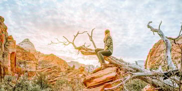 Woman hiking in a canyon looking at the sunset