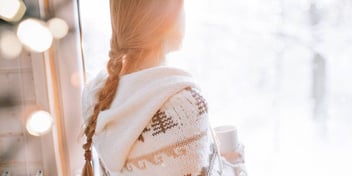 Woman looks out over snow 