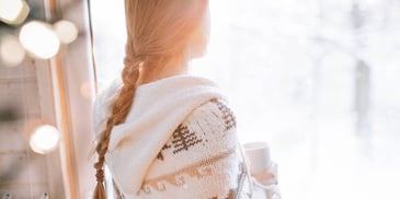 Woman looks out over snow 