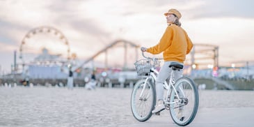 Woman stops her bike along a beach boardwalk
