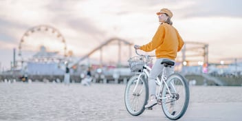 Woman stops her bike along a beach boardwalk