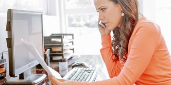 woman looking at a divorce petition and talking on the phone