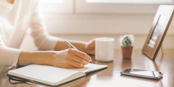 Womans uses a notebook at her desk