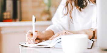 woman taking notes in preparation for filing for divorce