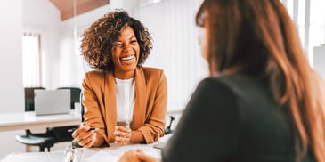 two women meeting in an office and laughing together