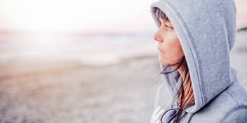 worried woman standing on the beach