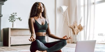 beautiful young black woman meditating after yoga