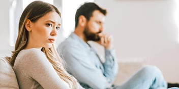 Young couple on a coach expressing disdain for one another