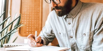 A young male writing in his notebook