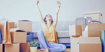 young woman sitting in middle of moving boxes